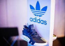 shallow focus photography of unpaired gray adidas sports shoe